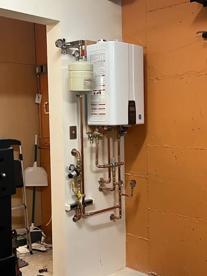Plumbing technician inspecting water heater connections in East Kapolei